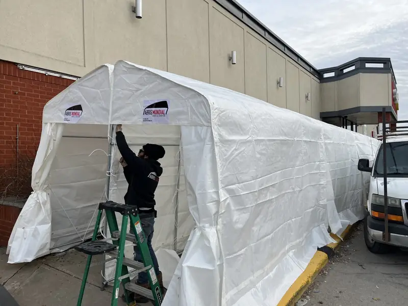 Installateur posant une toile à l'arrière d'une épicerie