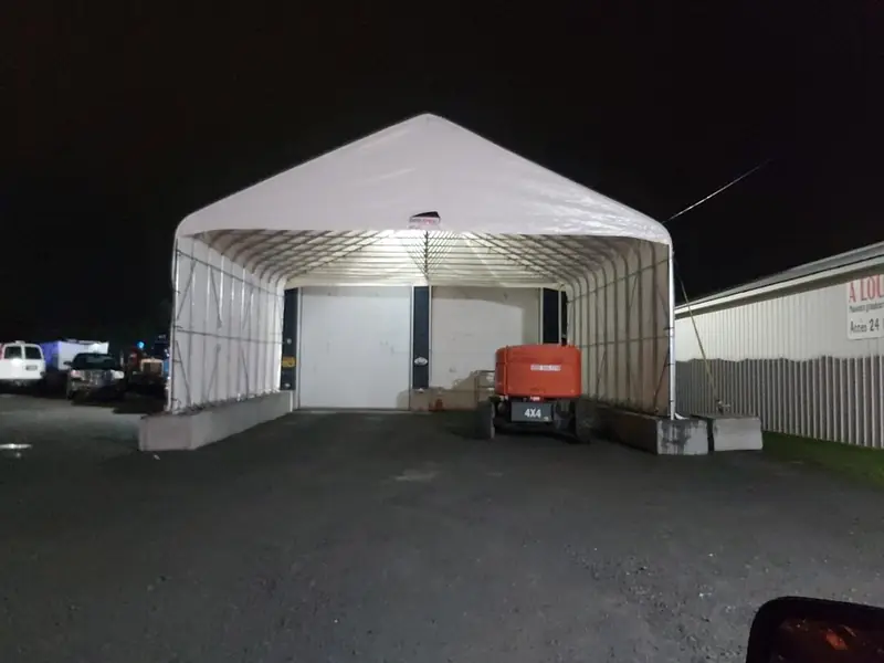 Abri éclairé au-dessus d'une porte de chargement, la nuit